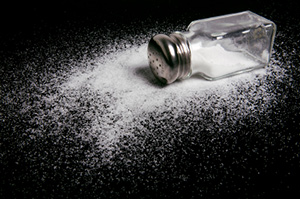 tipped over saltshaker with salt spilled all around