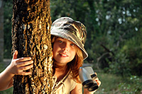 Girl behind tree in golden light