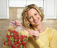 Woman holding ziploc® bag full of stawberries and kiwis
