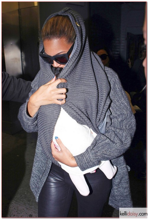 Singer Beyonce hiding her daughter Blue Ivy Carter under her sweater as she leaves a doctors office in New York City, NY on March 28, 2012.