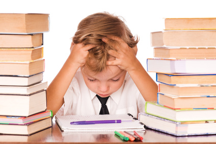 Portrait of a cute little boy sitting in library before books. Isolated over white background.