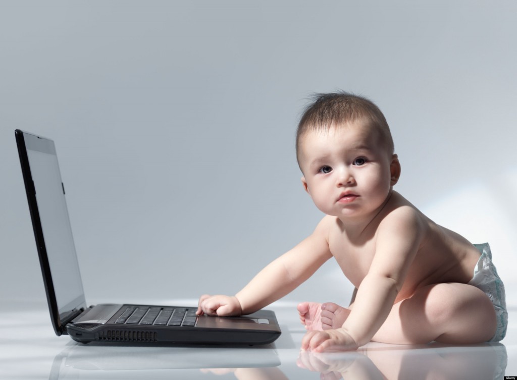 BWJX6P Six month old baby sitting in front of a laptop computer