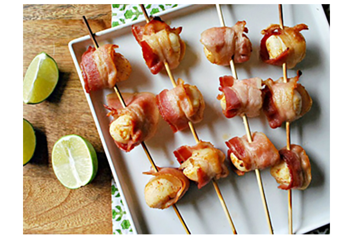 Culinary landlubbers will easily be swayed in the direction of seafood with these bacon-wrapped scallop skewers, an easy meal to serve with a simple green salad for light summer eating. The scallops are slightly sweet and silky, and the bacon adds a salty and crisp addition to this weeknight dinner. 