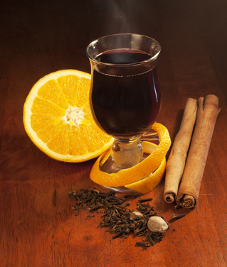 Mulled wine with orange and spices on dark background