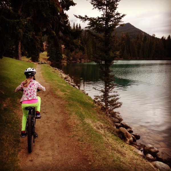 Girl-riding-bike-along-lake