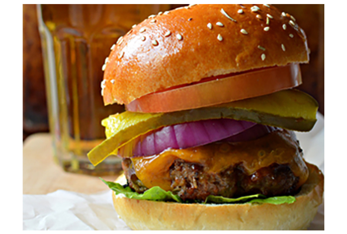 These big and beefy burgers are infused with a touch of beer, then brushed with a beer-based barbecue sauce while cooking. Be sure to butter and toast the buns before topping with the grilled patties—it will provide a barrier and keep the bread from turning soggy. 