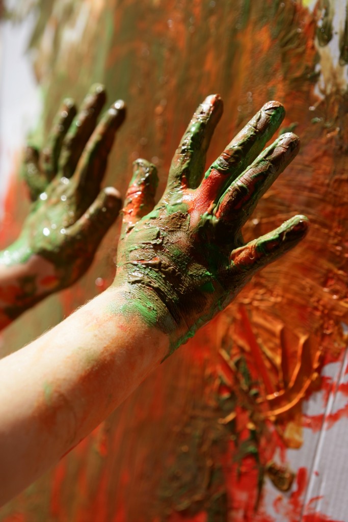 Children artist hands painting colorful with her fingers