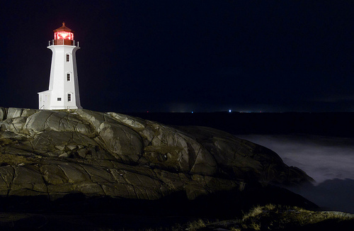 The rocks at Peggy's Cove are notoriously dangerous, and a layer of ice on them certainly doesn't help things.
This shot was captured late in the evening during a winter storm, though the conditions are brutal out in the open, they cease immediately when you step behind a rock. 
Thank goodness for that!