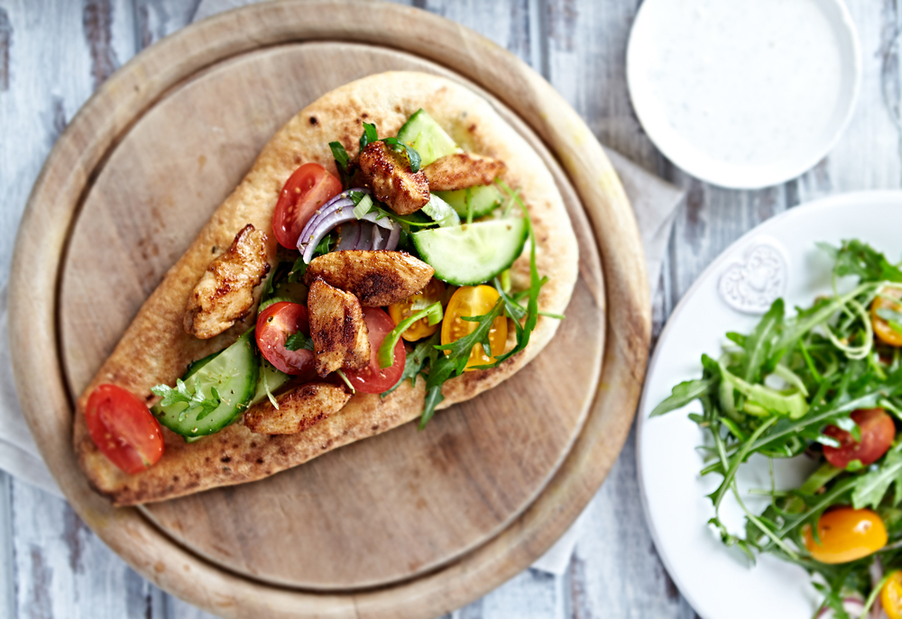 Flatbread topped with chicken and tomato cucumber salad