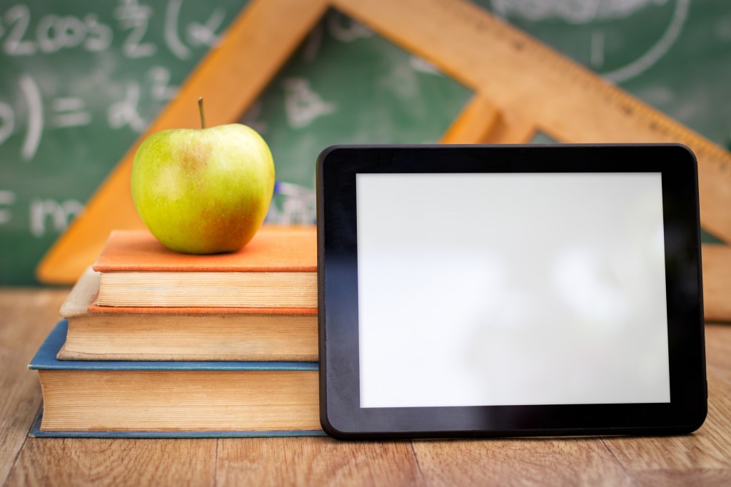 Empty tablet pc with books, technology and education