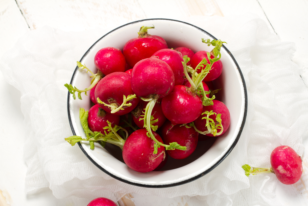 Whole Red radishes in white bowl