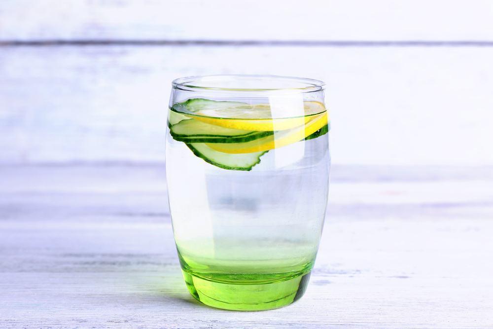 8 Reasons You should be drinking lemon water, glass of water with lemon and cucumber slices