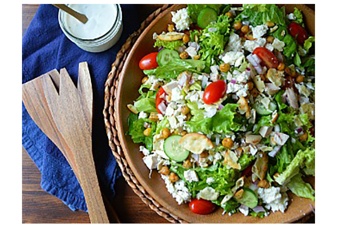 Deliver an impressive twist on a typical taco salad by swapping a few of the usual ingredients for their Mediterranean cousins. Here, feta stands in for cheddar, chickpeas replace beans, and tzatziki provides the familiar creaminess usually associated with sour cream. Top with shredded rotisserie chicken and crisp pita crackers for a no-cook meal the whole family will love. 