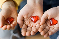 Three_hands_holding_hearts