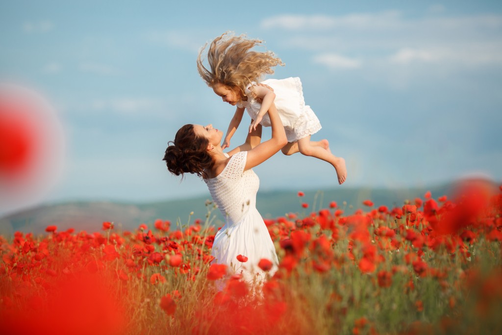 beautiful mother and little daughter in a field in summer beautiful mother and little daughter in a field in summer