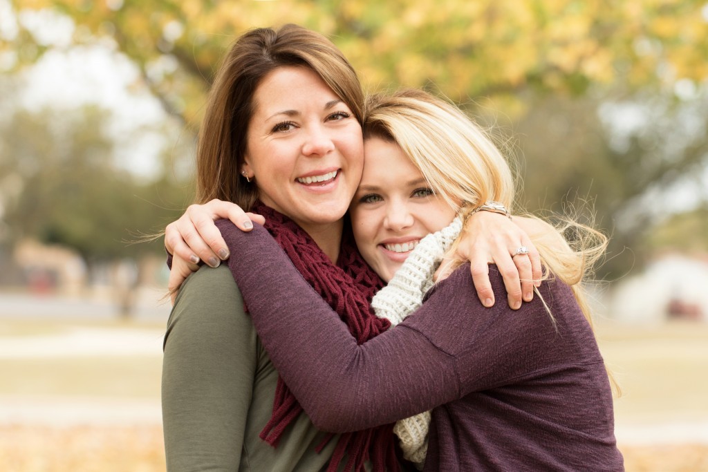 Mother and teenage daughter hugging.