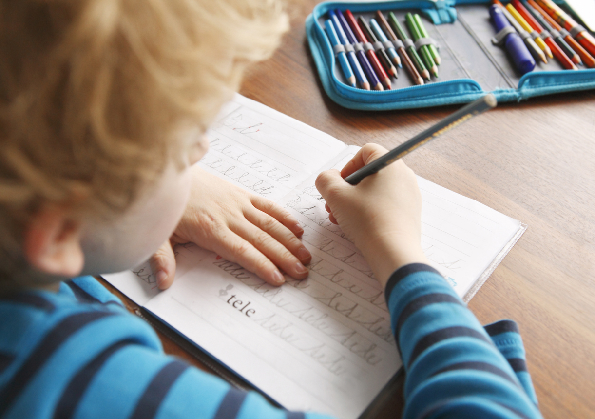 teacher writes note on students homework