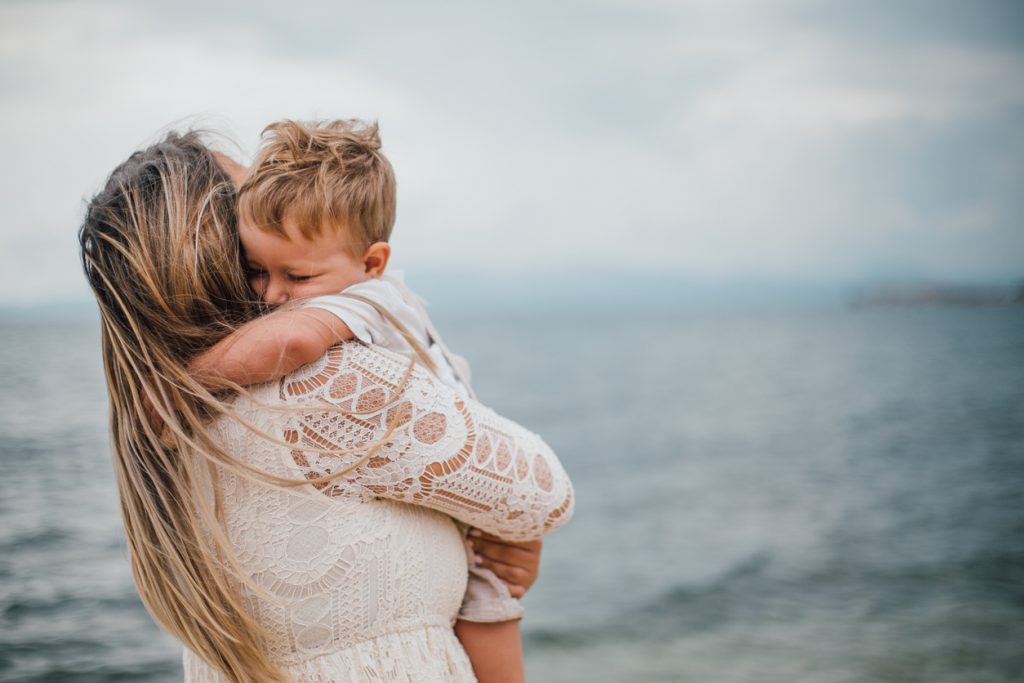 Alleinerziehende Mutter spielt am Strand mit ihrem Sohn