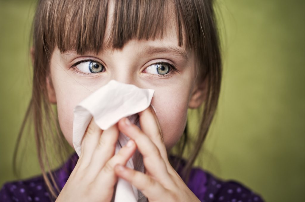 Little sick girl cleaning her nose