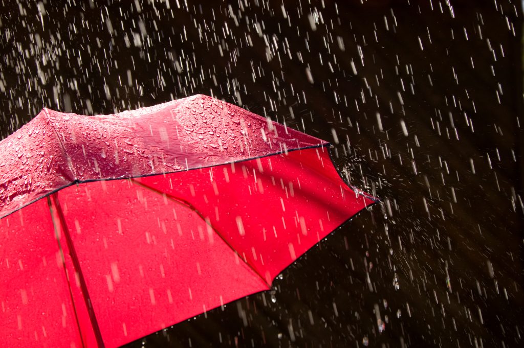 Red Umbrella and Rain Against Black Background