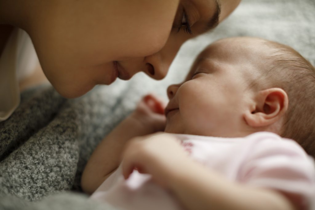 Mother and baby playing in the bed