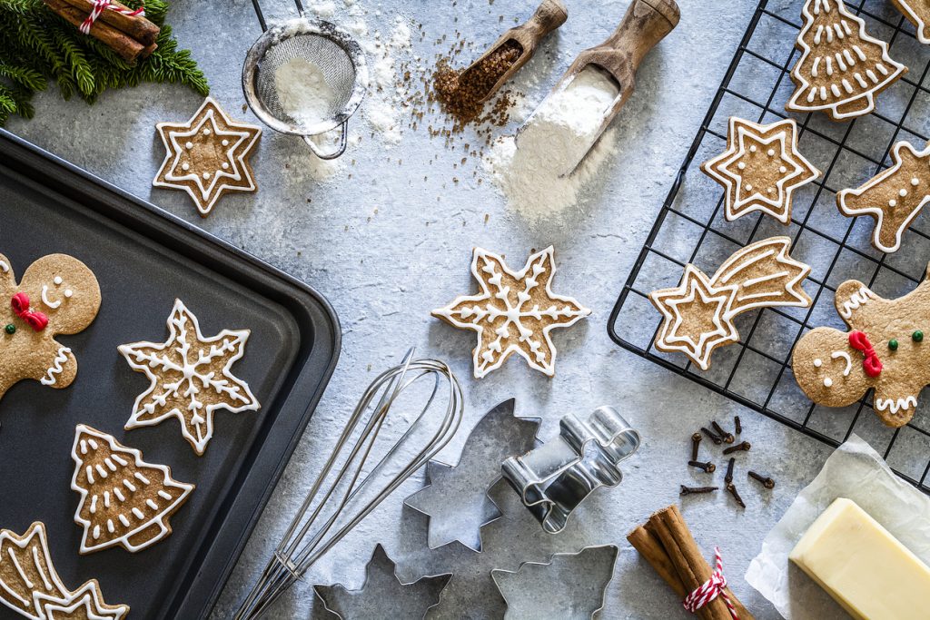 Top view of a gray table with ingredients and utensils for preparing and baking Christmas cookies. Predominant colors are brown and gray. Low key DSRL studio photo taken with Canon EOS 5D Mk II and Canon EF 100mm f/2.8L Macro IS USM