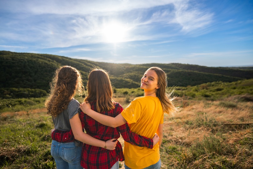 Happy girls stand hugging on the hill during sunset I Am a Good Mom. And I Didn't Always Get It Right - SavvyMom