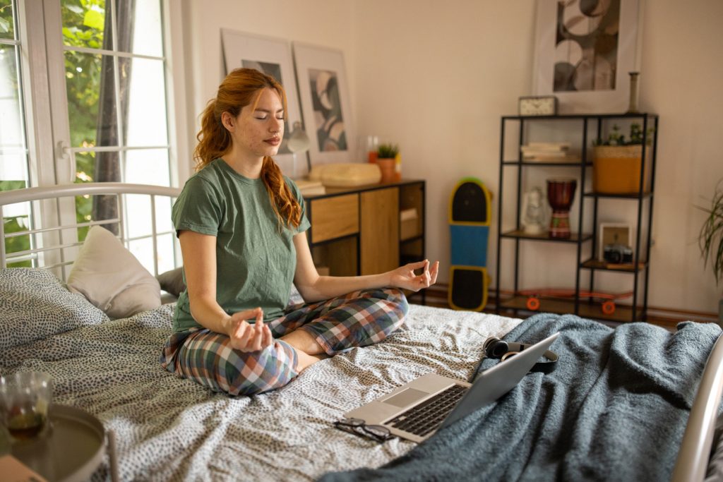 Young woman meditating in her bedroom Self Care Is Stupid... Until It Isn't - SavvyMom