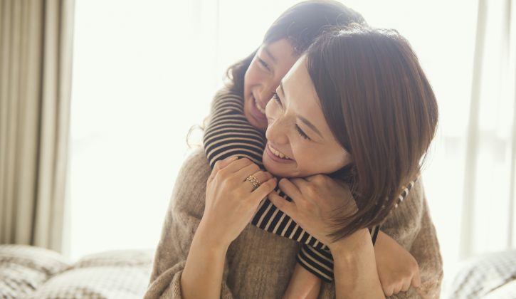 Mother and daughter having fun time in bed room