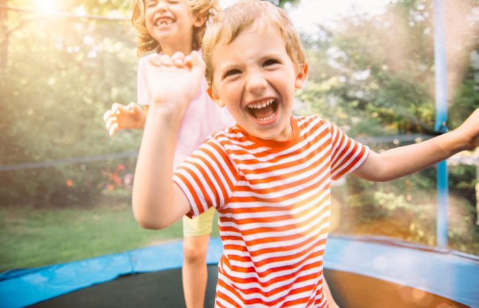 Children having fun on summer vacation jumping on trampoline
