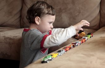 Autistic boy lining up cars to achieve order in his world.