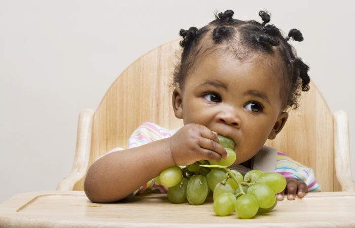 Baby girl eating grapes