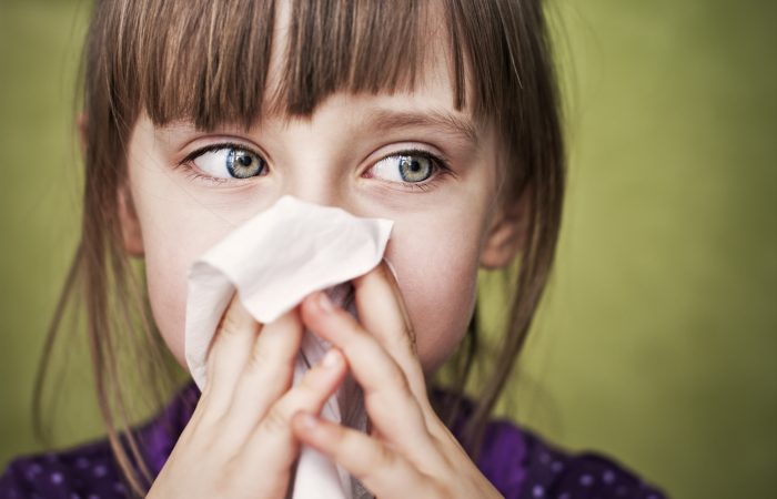 Little sick girl cleaning her nose