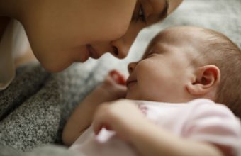 Mother and baby playing in the bed