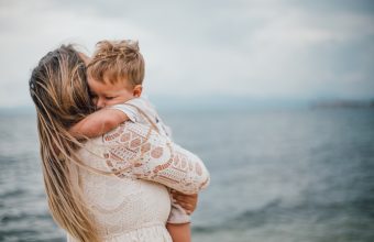 Alleinerziehende Mutter spielt am Strand mit ihrem Sohn