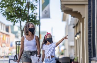 African American mother and daughter shopping downtown while wearing masks