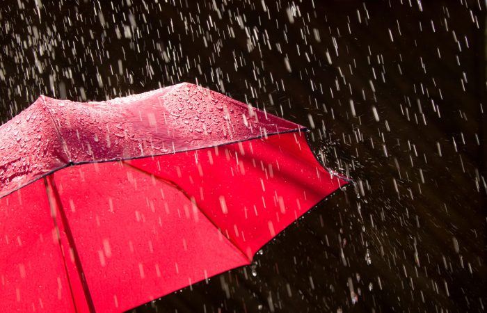 Red Umbrella and Rain Against Black Background