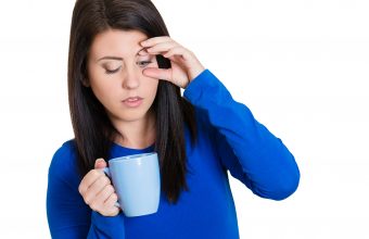 Portrait tired falling asleep woman employee holding cup coffee