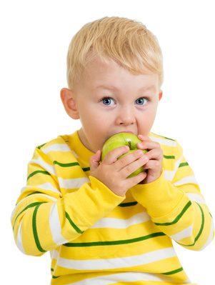 Kid boy eating green apple, isolated on white