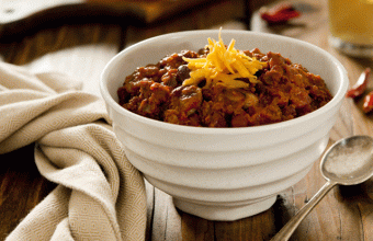 Bowl of smoky sirloin beef chili with cheddar cheese