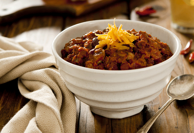 Bowl of smoky sirloin beef chili with cheddar cheese