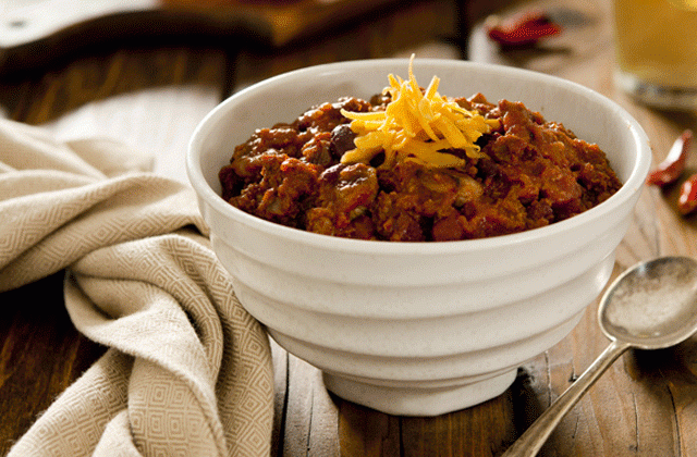 Bowl of smoky sirloin beef chili with cheddar cheese