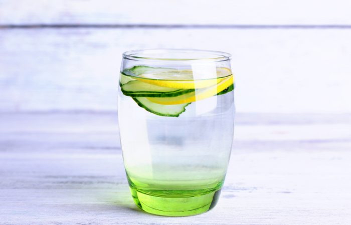 8 Reasons You should be drinking lemon water, glass of water with lemon and cucumber slices