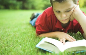 boy-reading-book-outside