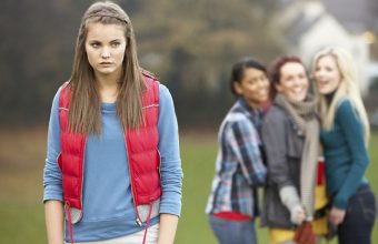 226671-upset-teenage-girl-with-friends-gossiping-in-background