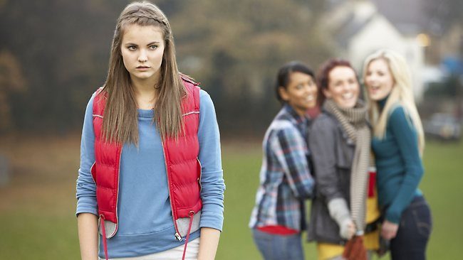 226671-upset-teenage-girl-with-friends-gossiping-in-background